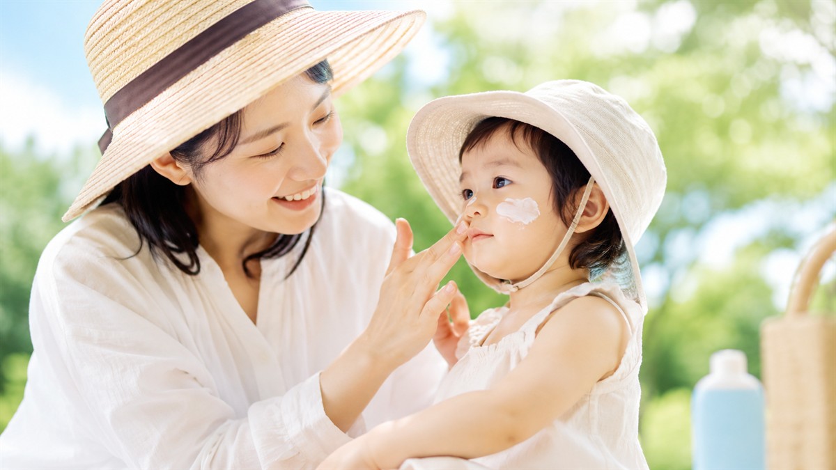 子どもに日焼け止めを塗ってあげるお母さん