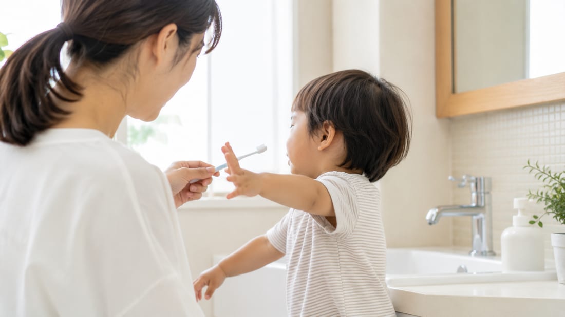 洗面所で歯ブラシをいやがる小さな子どもの様子