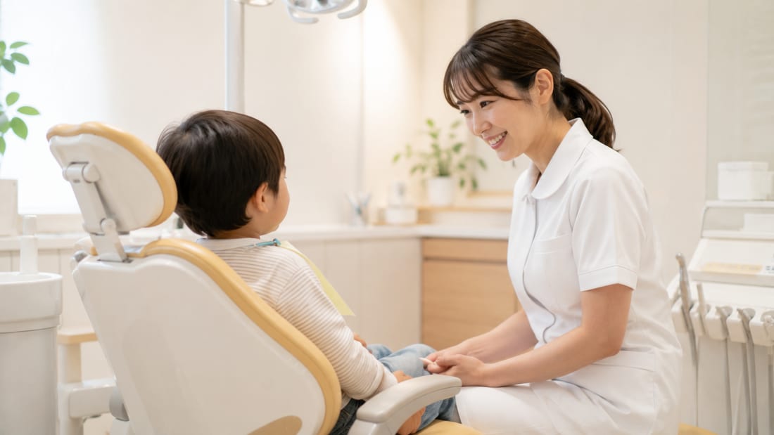 小児歯科の診察室でやさしく対応する歯科衛生士と子ども