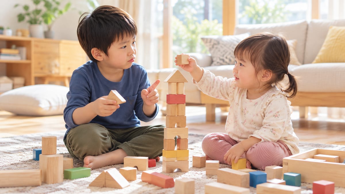 木の積み木で塔を作りながら話し合う兄と妹